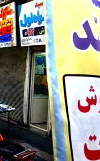 شاگرد بساطی جلو در مغازه اکبرآباد نسیم شهر۱۶ سال