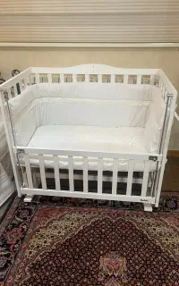 گهواره چوبی کنار تخت مادر