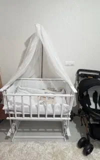 گهواره و تخت چوبی کنار مادر