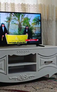 تلویزیون با میز جاکفشی بخاری جارو برفی و پرده