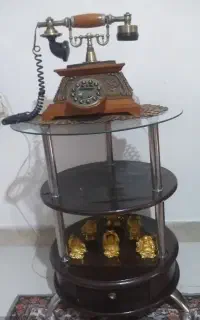 گوشی تلفن ثابت به همراه میز و مجسمه دکوری