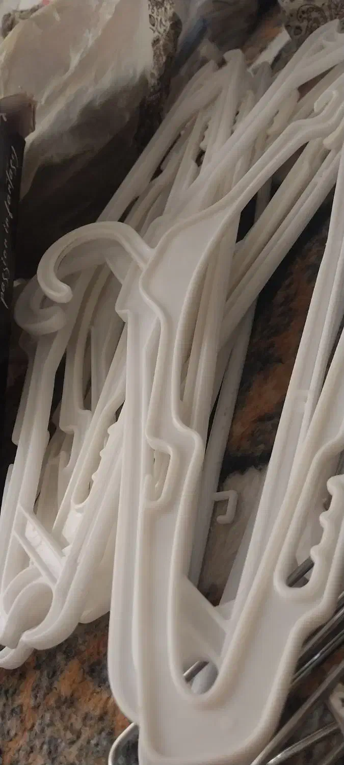 مقداری آویز لباس در رنگهای سفید سیاه و فلزی|بندرخت و رخت‌آویز|لاجان, |دیوار