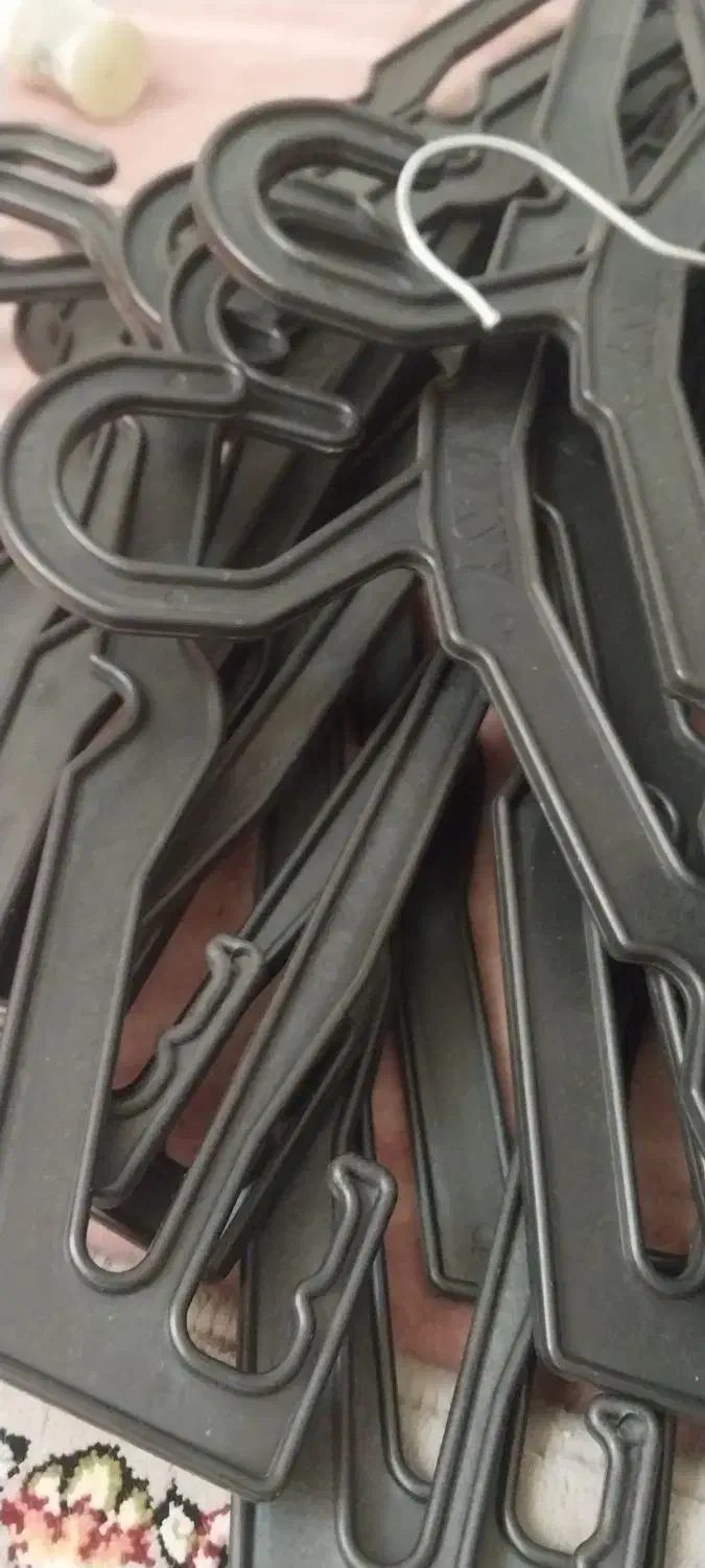 مقداری آویز لباس در رنگهای سفید سیاه و فلزی|بندرخت و رخت‌آویز|لاجان, |دیوار