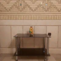 میز دو طبقه شیشه ای دودی رنگ با پایه های استیل