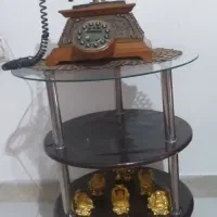 گوشی تلفن ثابت به همراه میز و مجسمه دکوری
