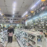 فروشنده خانم فروشگاه کفش فروشی شلوغ بازار