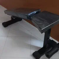 نیمکت ورزشی و یک جفت دمبل ۱۰ کیلویی