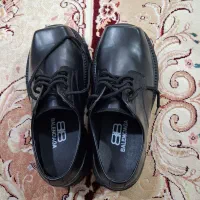 یک جفت کفش مردانه لژدار جلو تخت. نو