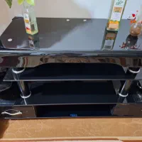 میز تلویزیون شیشه  خم سه طبقه در حد نو