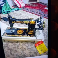 چرخ خیاطی قدیمی ک عکس شیرخورشید‌روش خورده