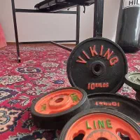 میز پرس خانگی هالتر و چهل و پنج کیلو وزنه