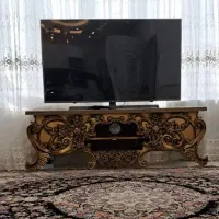 ساعت و میزتلویزیون طلایی و پرده و درب اتاق