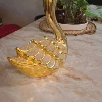 یک عدد ساعت رومیزی و یک عدد مجسمه قو