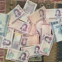 تعدادی اسکناس ۱۰۰ ریالی و ۲۰۰ ریالی