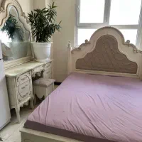 تخت خواب و آیینه کنسول و صندلی و کمد کوچک کنارش
