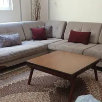 مبل ال خاکستری با یک مبل تکی و میز جلو مبلی