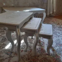 یک میز بزرگ سفید رنگ و سه عسلی