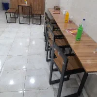 پنج عدد صندلی یک میز دوتا نیمکت