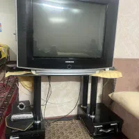 دو عدد تلویزیون همراه با میز و دستگاه دیجیتال