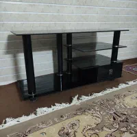 میز تلویزیون شیشه‌ای تمیز و نو با یک کشو