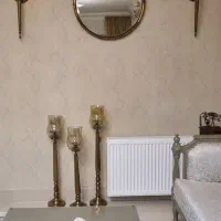 ایینه و شمعدان های دیواری و سه پایه کنار سالنی