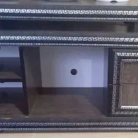 یک عدد میز تلوزیون و تلوزیون و دستگاه دیجیتال