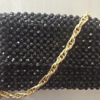 کیف مرواریدی تراش دار مشکی با بند طلایی و رنگ ثابت