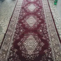 یک تخت فرش شگی قرمز و یک کناره