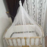 تخت خواب گهواره‌ای نوزاد کنار مادر