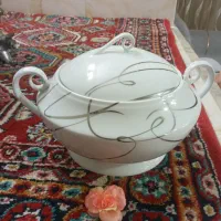 یک عدد سوپ خوری با یک ساعت دیواری