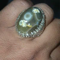 انگشتر باباقوری کهنه شکل یه گل داخل سنگ هست