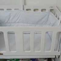 یک عدد تخت نوزادی گهواره‌ای کنارمادر