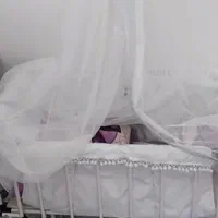 گهواره نوزاد متحرک کنار تخت