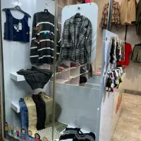 ویترین مغازه با همه قفسه ها و پیشخوان و رگال لباس