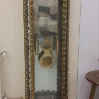 ساعت برنجی محکم پشتش آینه وبالاش دوطاوس داره