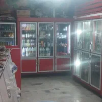 تعدادی یخجال و قفسه فروشگاهی با میز و ...