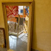 آیینه طلایی بزرگ و تخت چوبی همراه با خوشخواب