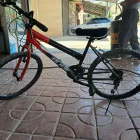 دوچرخه دندەای رنگ قرمز و سیاە