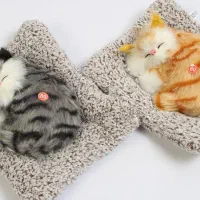 عروسک گربه ی خوابیده روی بالشت