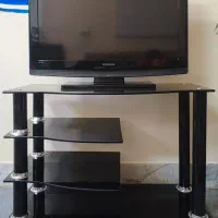 تلویزیون به همراه میز شیشه ای