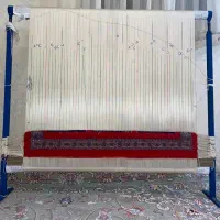 دار قالی به همراه نخ و نقشه و مقداری بافته شده