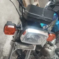 موتور هندا همراه با کلاه کاسکت و زنجیر چرخ