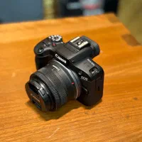 دوربین کانن EOS R100 با لنز 18-45 تمیز و کم‌کارکرد