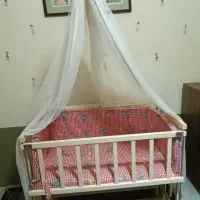 گهواره نوزاد و تخت کنار مادر