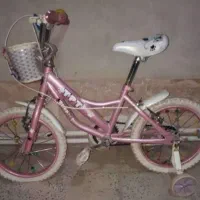 یک عدد دوچرخه صورتی به همراه اسکوتر صورتی