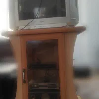 میز و تلویزیون و دستگاه دیجیتال و اسپیکر