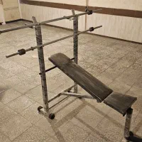 میز پرس به همراه میله هالتر و وزنه و دمبل