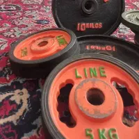هالتر خانگی با گیره مخصوص و تعدادی وزنه فلزی