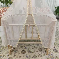 گهواره نوزاد و تخت کنار مادر