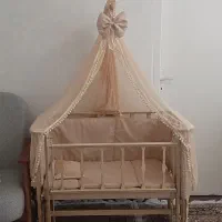 تخت گهواره‌ای کنار مادر چوبی